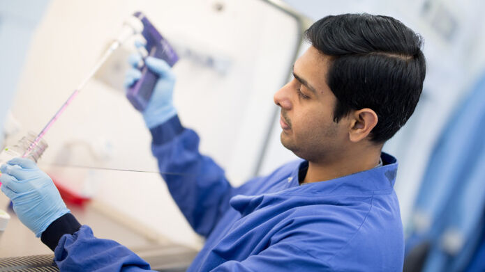 male student holding pipette in lab