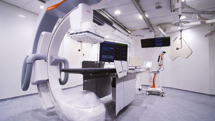 A hospital room featuring a large medical device, equipped with various monitors and medical supplies for patient care.