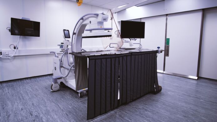A hospital room featuring a large medical device, equipped with various monitors and medical supplies for patient care.