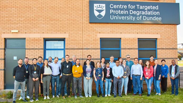 A large group photo of members of the CeTPD standing outside of the building