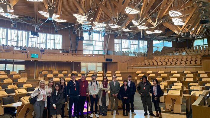 A group of students pose for a group picture in the Scottish Parliament buildings