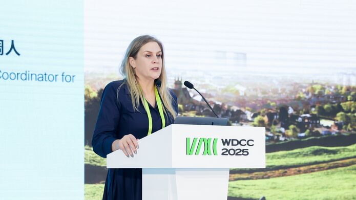 woman standing at podium, outside in a park