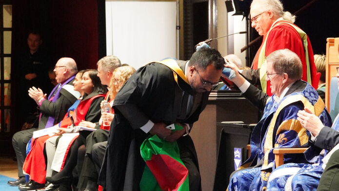 Student walking across graduation stage