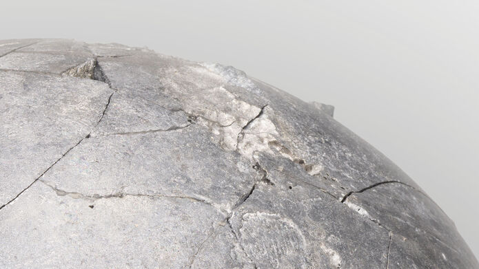 A section of a grey concrete looking sphere, against a pale grey background.