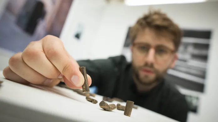 Nick Brodie with his bronze casts of cigarette butts