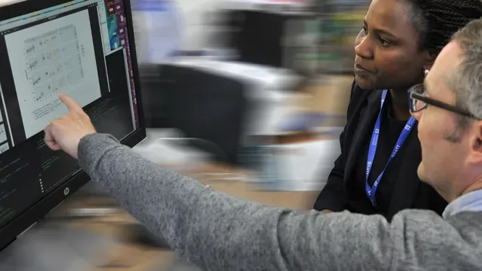 Researchers analysing data and graphs on screen