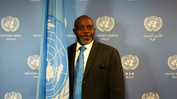 Justice Tettey stands beside a UN flag