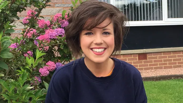 Kirsty in front of some flowers