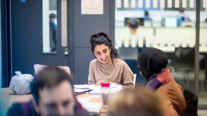 students studying at a table in the library