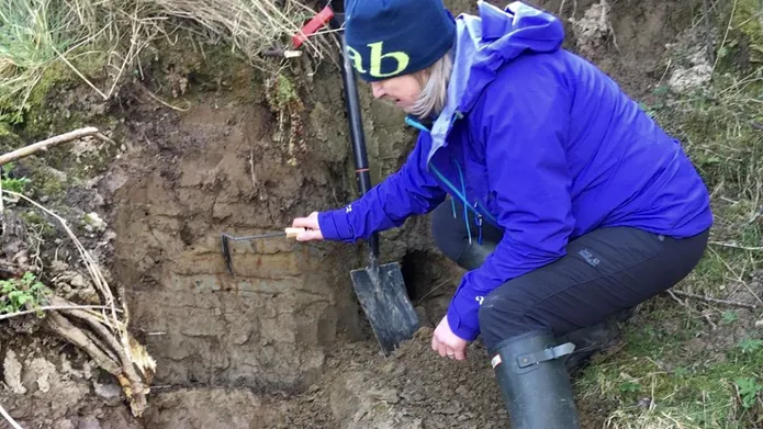 Sue Dawson looking at mud