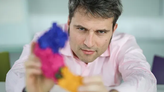 Professor Alessio Ciulli holding a blurry model