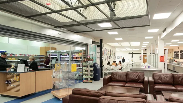 2 brown leather sofas, people sitting and some food on display to buy