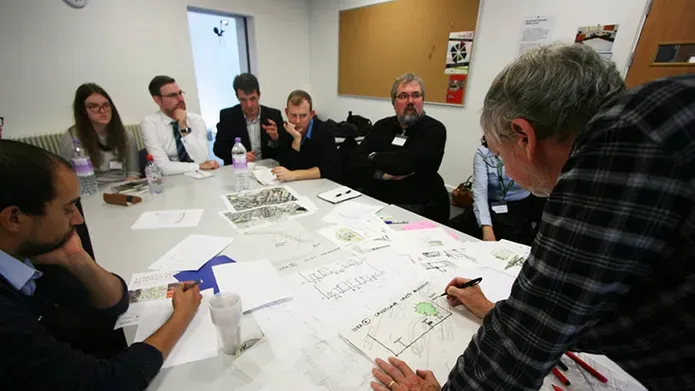 Students sitting round table working on a project together
