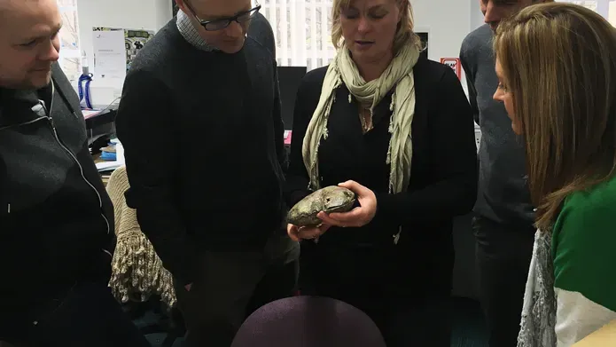 a group of people standing around a table 