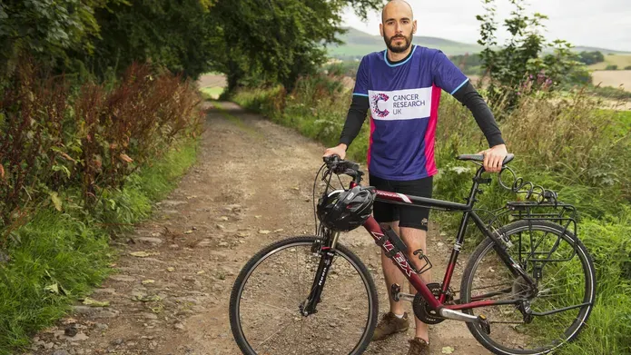Dr de la Vega standing by bike