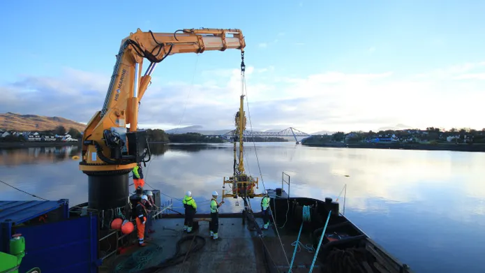 a group of men operating a winch aboard a vessel