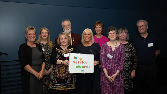 a group of people facing the camera and smiling for a photo