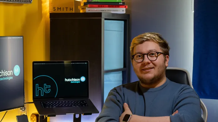 Callum sitting in his office at a desk with a computer on it
