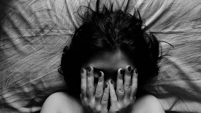 women laying on pillow covering face 