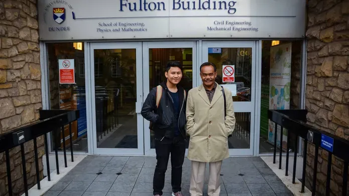 Hakim and Dato standing in front of the Fulton Building's main doors