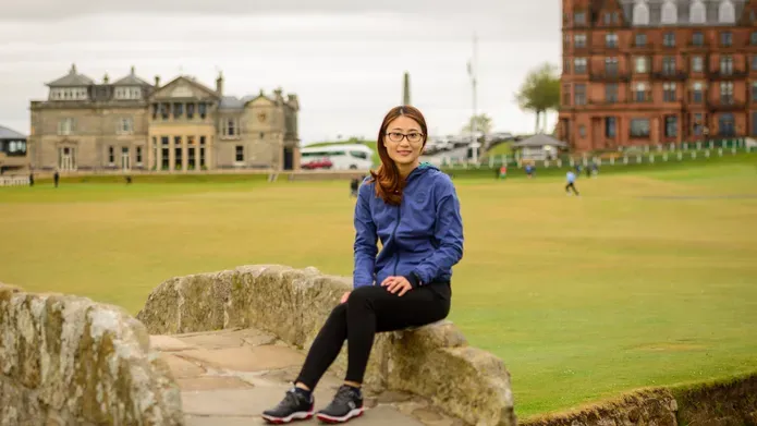 Yan Jiang sitting on the Swilken Bridge in St Andrews, on the Old Course