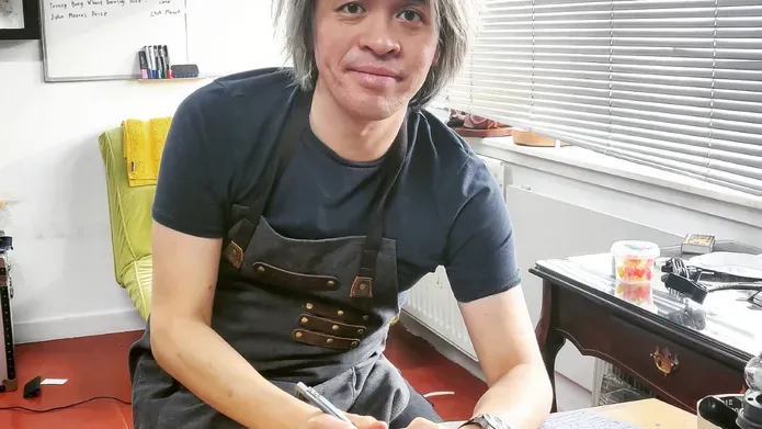 an image of Frank sitting at a desk drawing