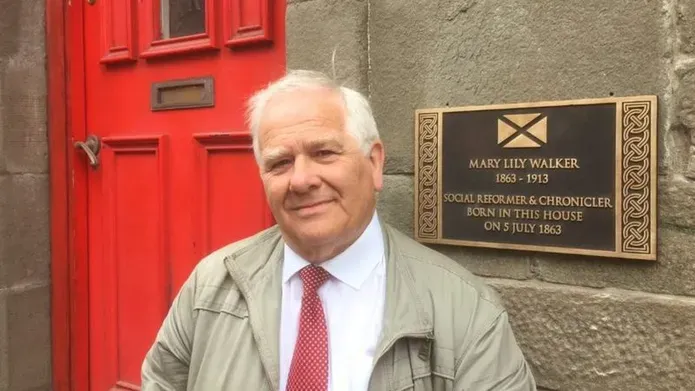 Eddie Small standing in front of the door of Mary Lily Walker's house