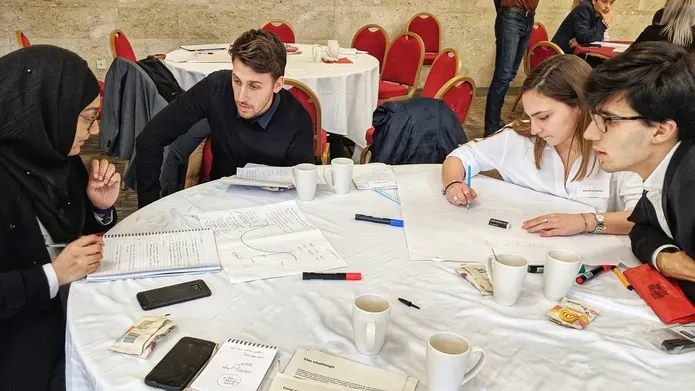 a group of people sitting around a table working