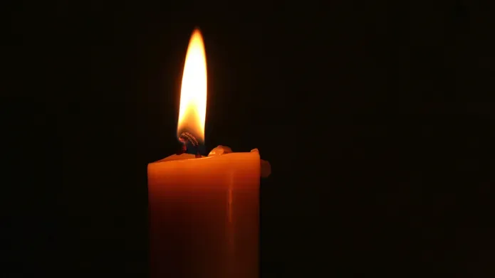 Red candle in front of black background