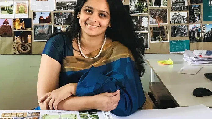 Aishwarya Tipnis with a wall of photos behind her