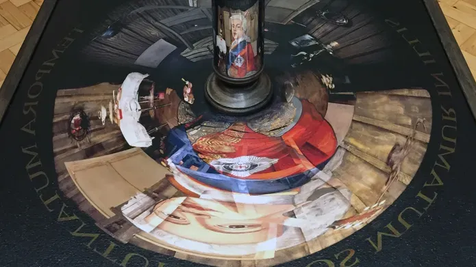 Mirrored tube on painting, which shows a face in the mirror if seen at a certain angle