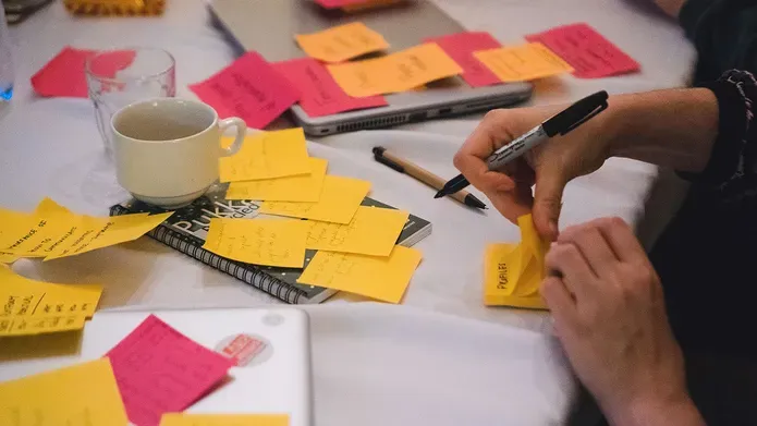 a table with someone writing post-its