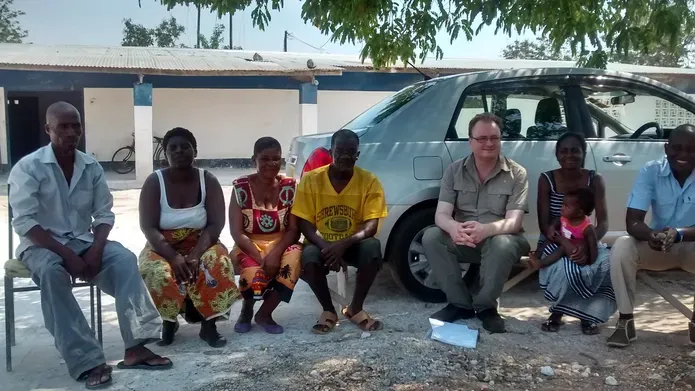 a group of people sit in front of a car