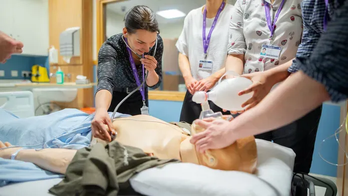 Undergraduate medicine students working with a dummy