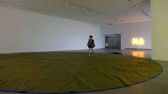 woman alone in gallery with circular fabric on floor