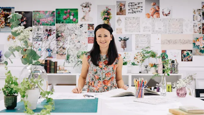 Hohanna with a wall behind her covered in drawings of flowers