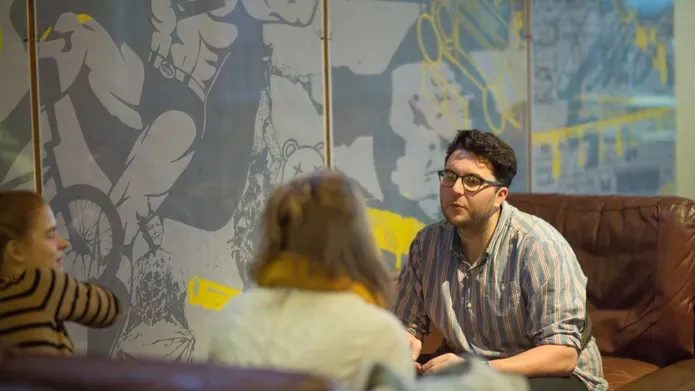 Students sitting in a coffee shop talking to each other