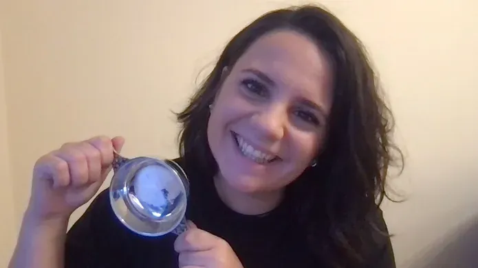 anna holding medal posing in front of plain wall