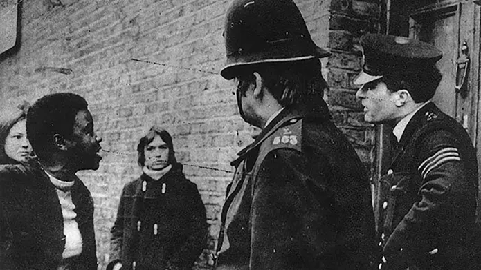 Black and white photo with police standing in front of people