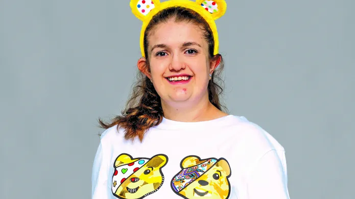 a young girl wearing yellow ears headband and white tshirt with four yellow bears