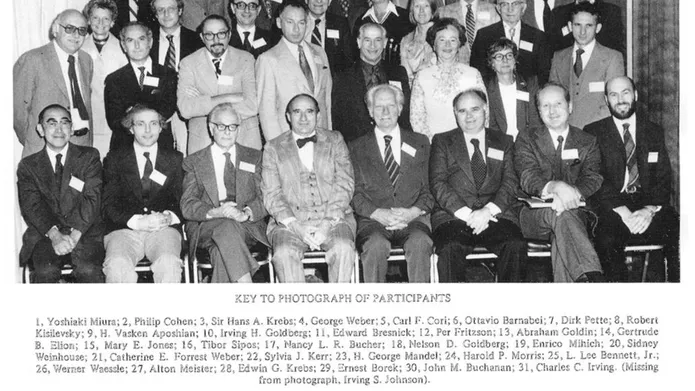 black and white photo showing group of people wearing suits and name badges