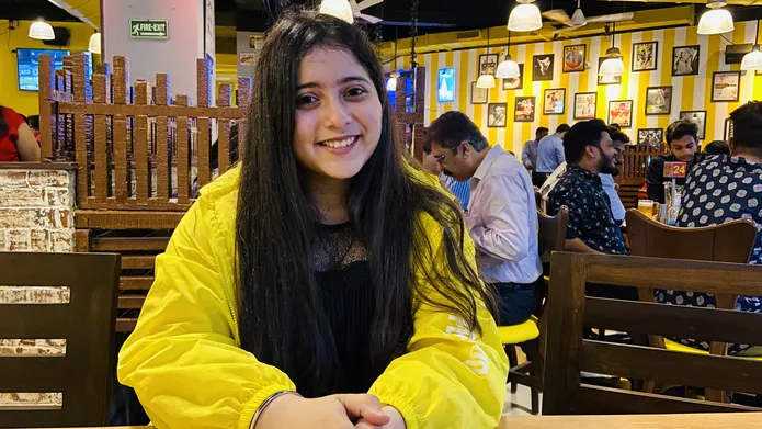 Young Indian student Ananya Bhatt sits in a restaurant
