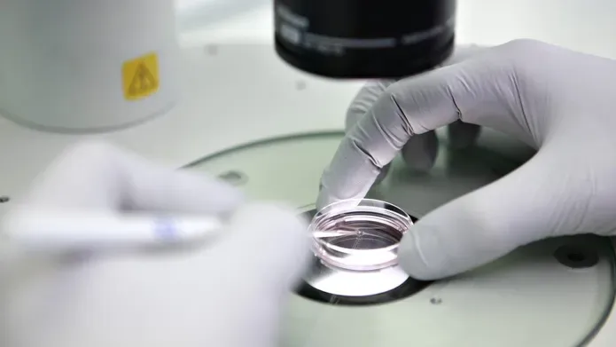 gloved hands holding specimen in circular glass container