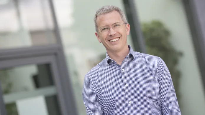 Prof Ewan Pearson smiling in angled outdoors shot