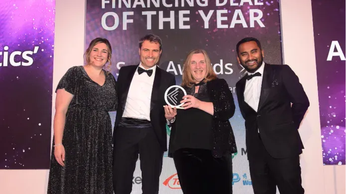 Scrip Awards - four people in evening dress standing in front of banner reading 'financing deal of the year'