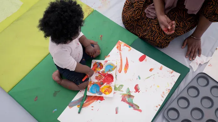 Baby and adult making art together