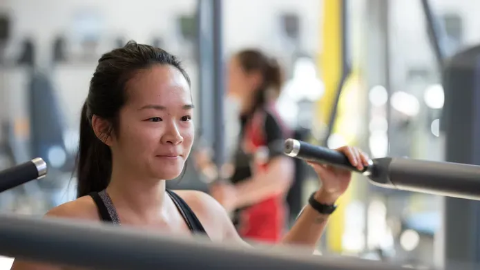 Girl using one of the machines in the gym.