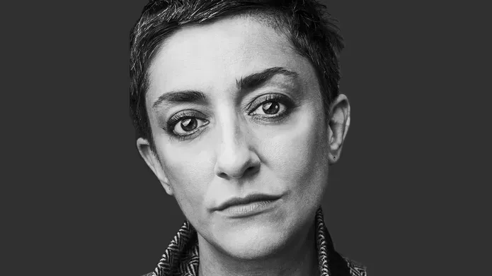 Maria Fusco black and white portrait against a dark grey background.