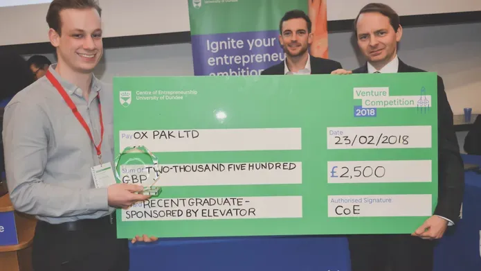 A student receives a novelty cheque for winning Venture Competition 2018