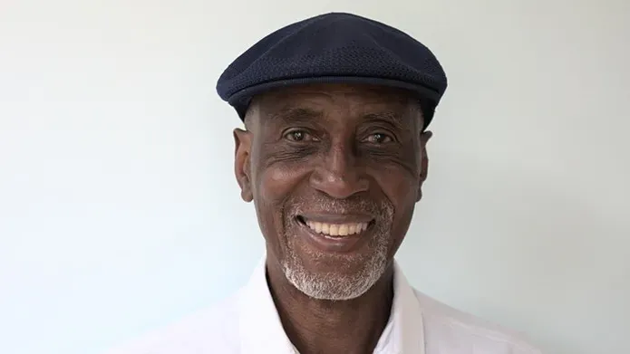 Keith Harris in a black cap and white shirt against white background